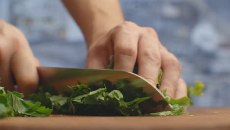 Close-up-of-cut-parsley-on-a-board-in-the-kitchen-with-a-knife